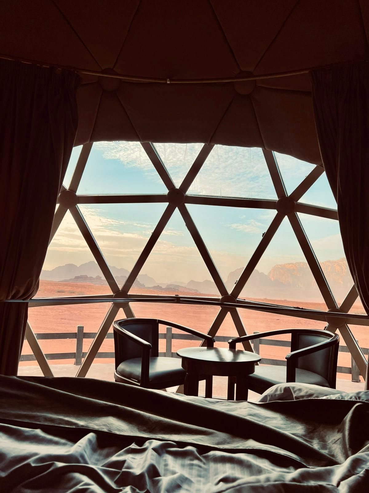 The desert at dusk through the dome window, from the bed