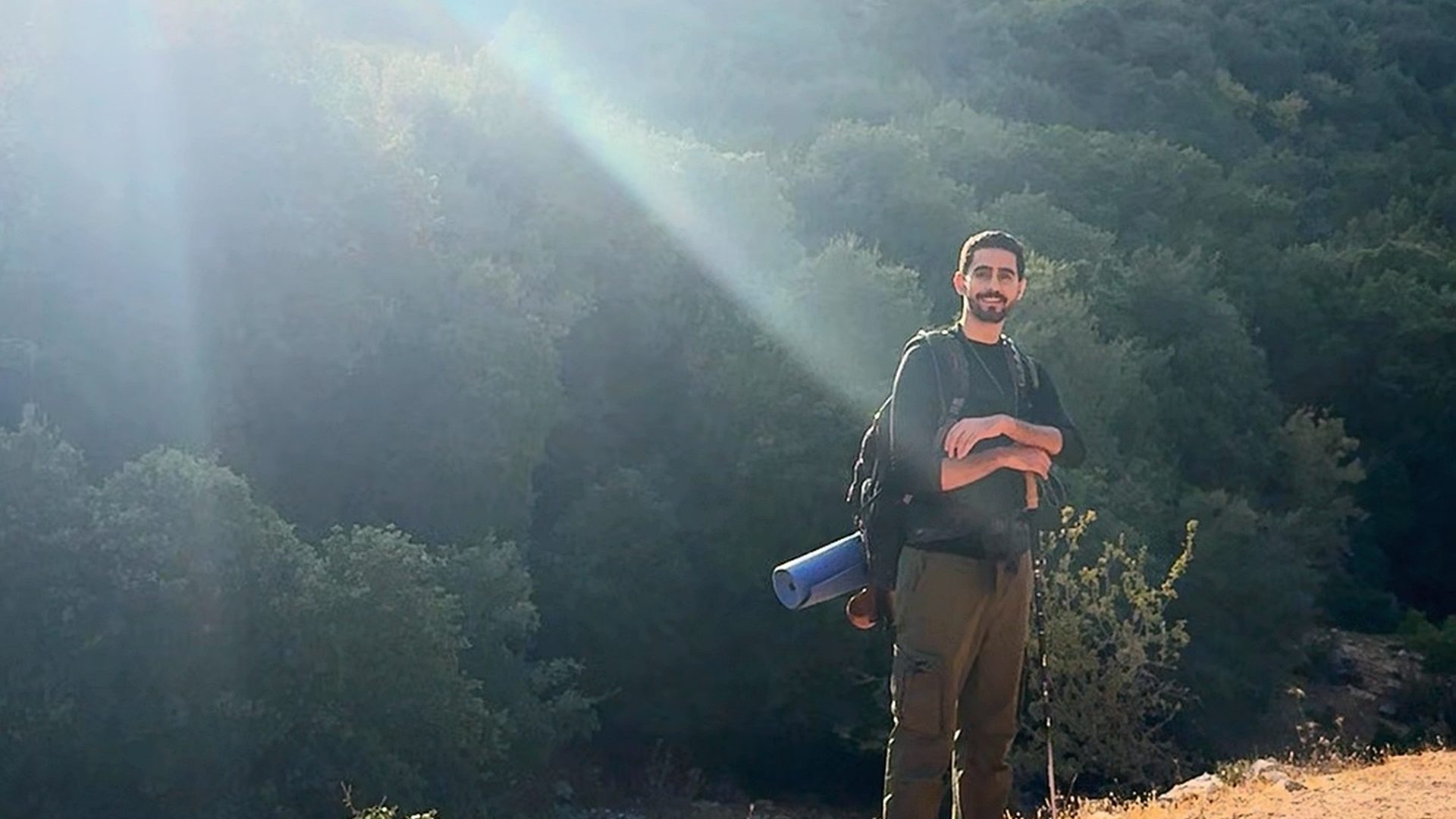 Standing in the sun rays on the ridge above the forest